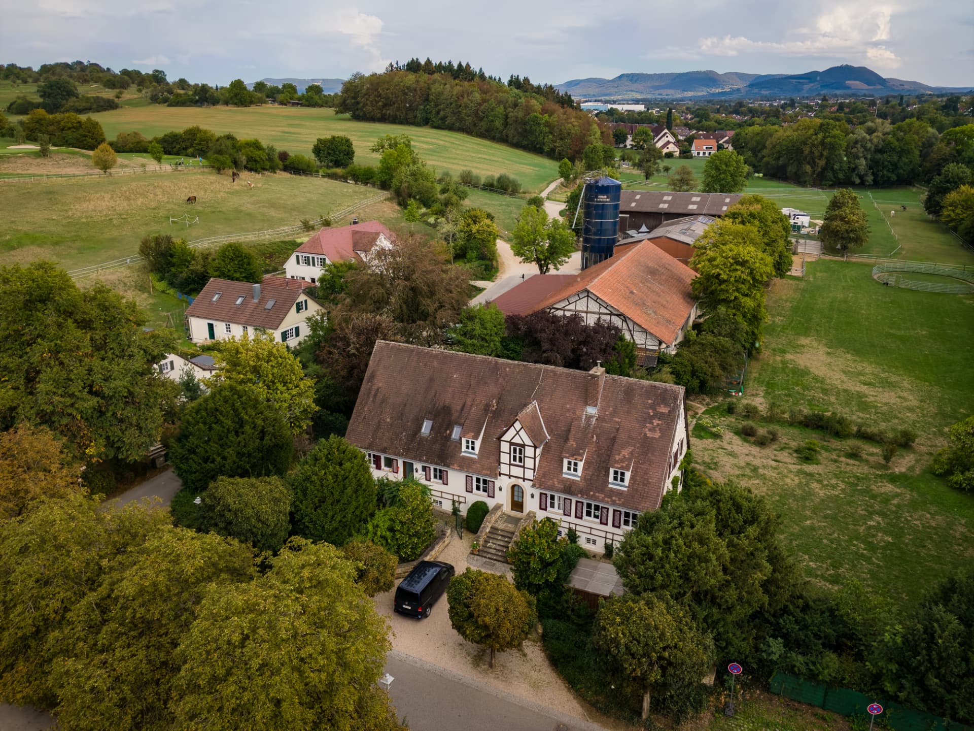 Luftbild des Neuen Hofs mit Fachwerkgebäuden, dahinter die Schwäbische Alb